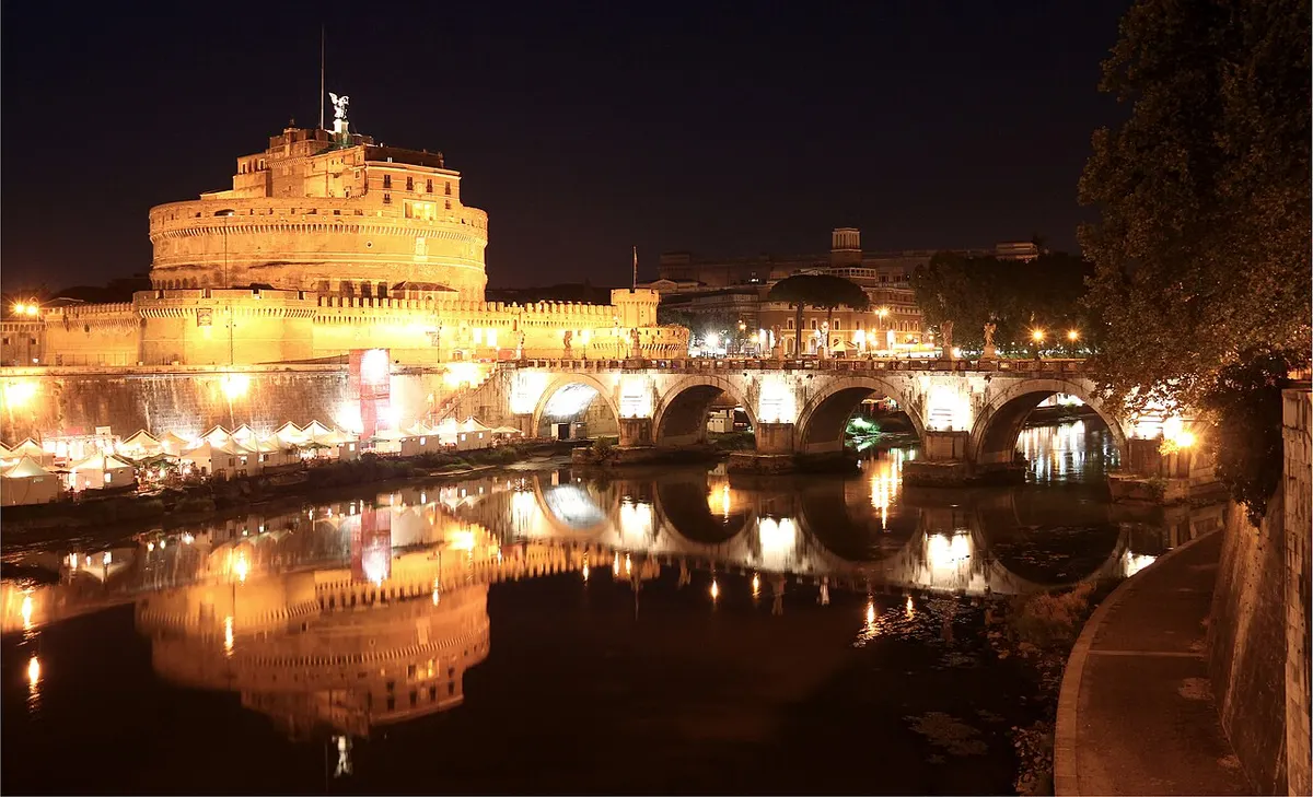 Ponte Sant’Angelo and Castel Sant’Angelo lit up at night over the Tiber in Rome