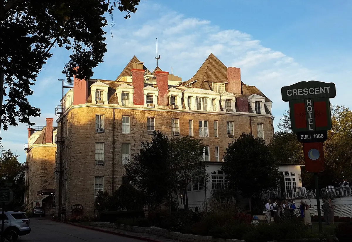 The limestone Crescent Hotel with its towers and balconies on a wooded hilltop in Eureka Springs