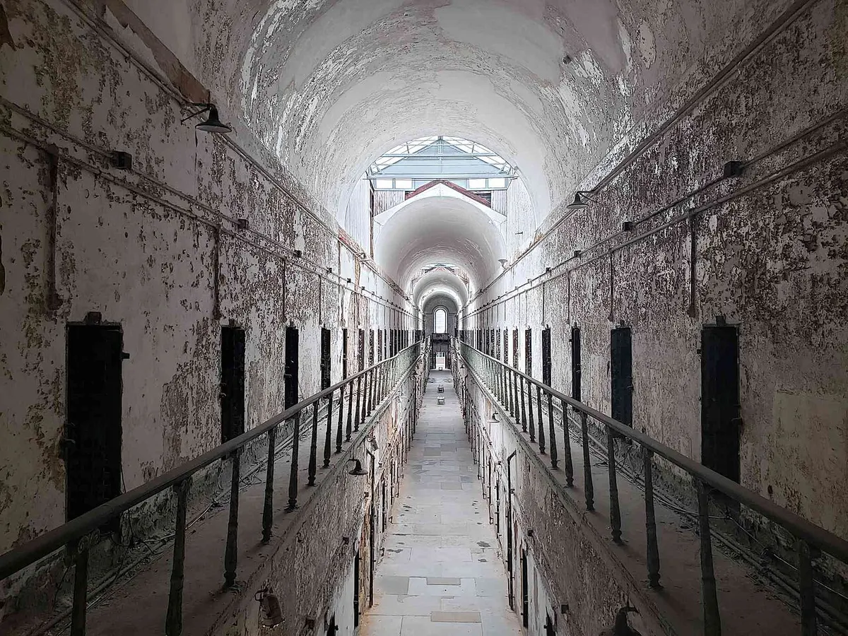 A long vaulted cellblock corridor lined with cell doors at Eastern State Penitentiary