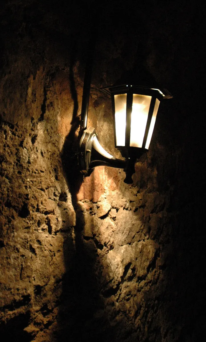 A dim, arched stone chamber inside the Edinburgh Vaults beneath the South Bridge