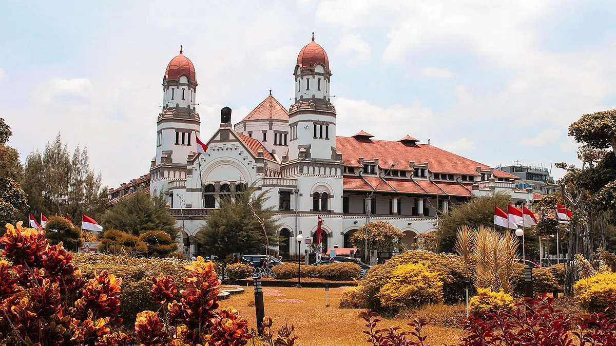 Lawang Sewu in Semarang, a large white colonial building with red-tiled roofs, arcaded windows and twin towers