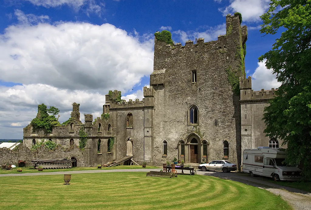 The tall gray stone tower house of Leap Castle with later wings, in County Offaly