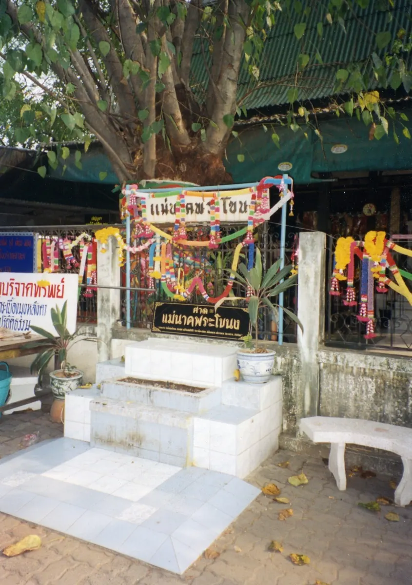 The Mae Nak shrine at Wat Mahabut in Bangkok, decorated with offerings, garlands and coloured cloth