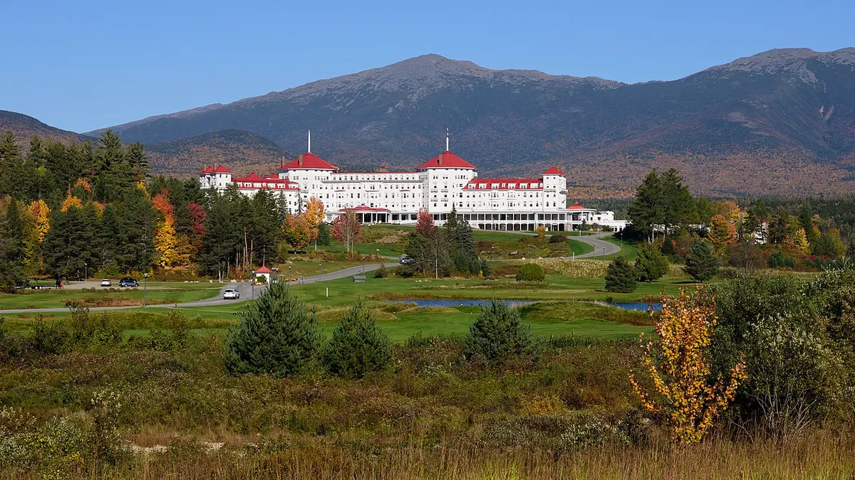 The white, red-roofed Mount Washington Hotel with the Presidential Range behind it