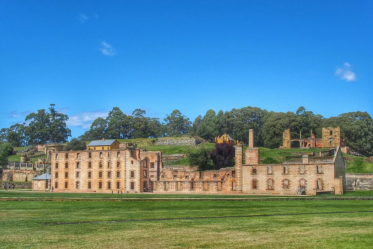 The roofless sandstone shell of the Penitentiary at Port Arthur beside the harbour