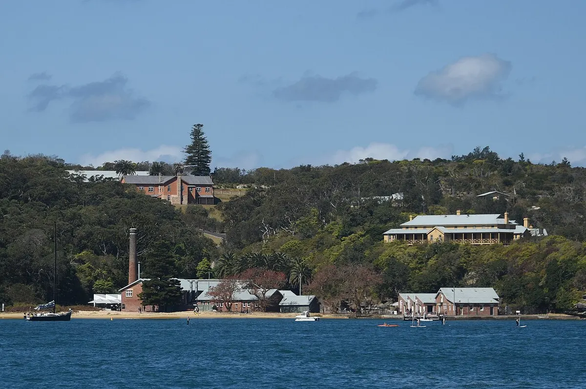The white buildings of the North Head Quarantine Station on the bushland shore of Sydney Harbour, seen from a Manly ferry
