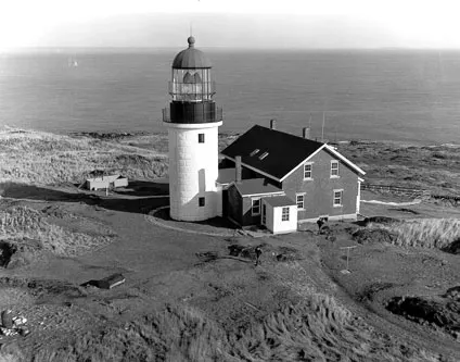 The granite Seguin Island lighthouse tower and keepers’ house on their rocky island off Maine
