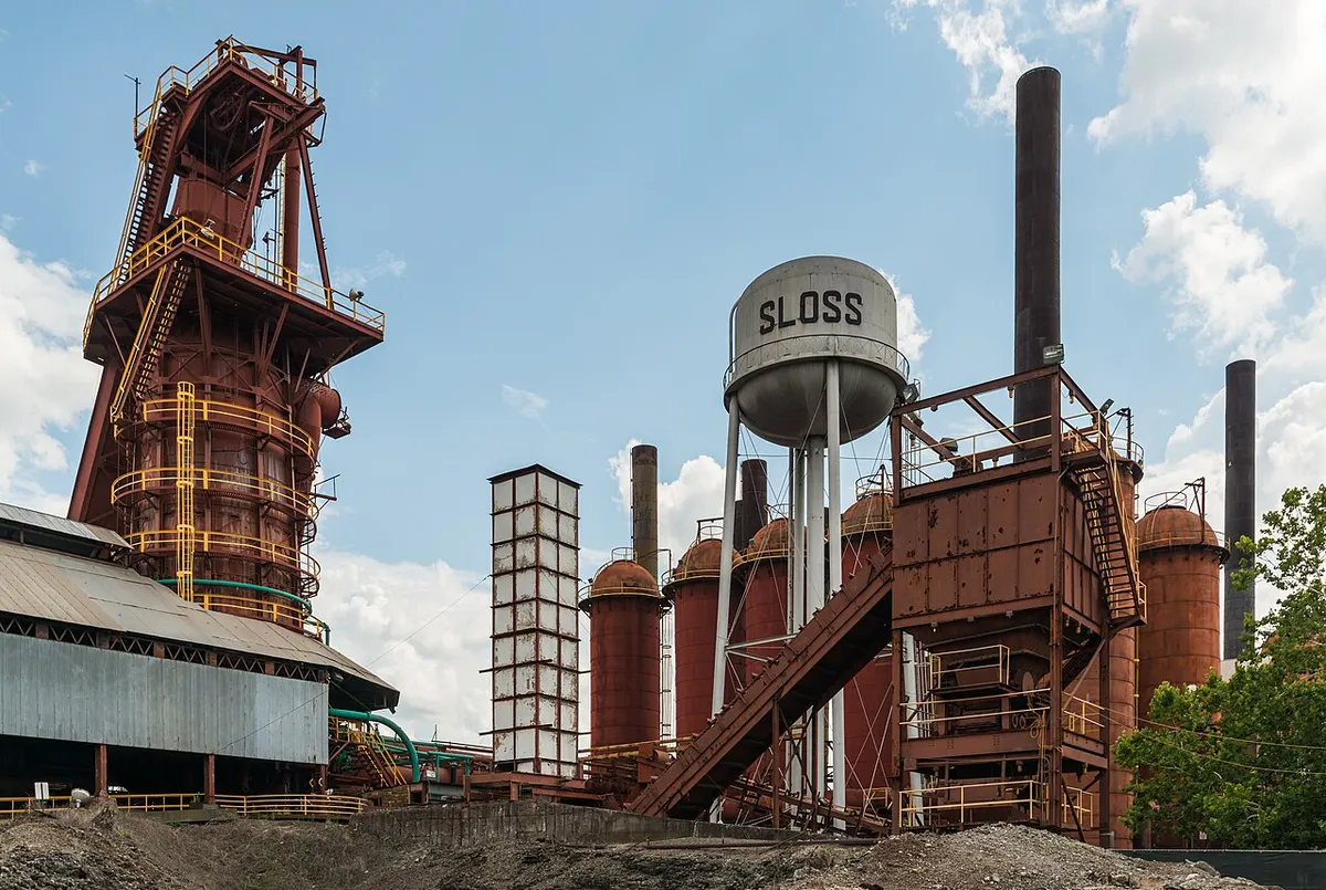 The rusted stacks and pipework of Sloss Furnaces seen from the north under a blue sky