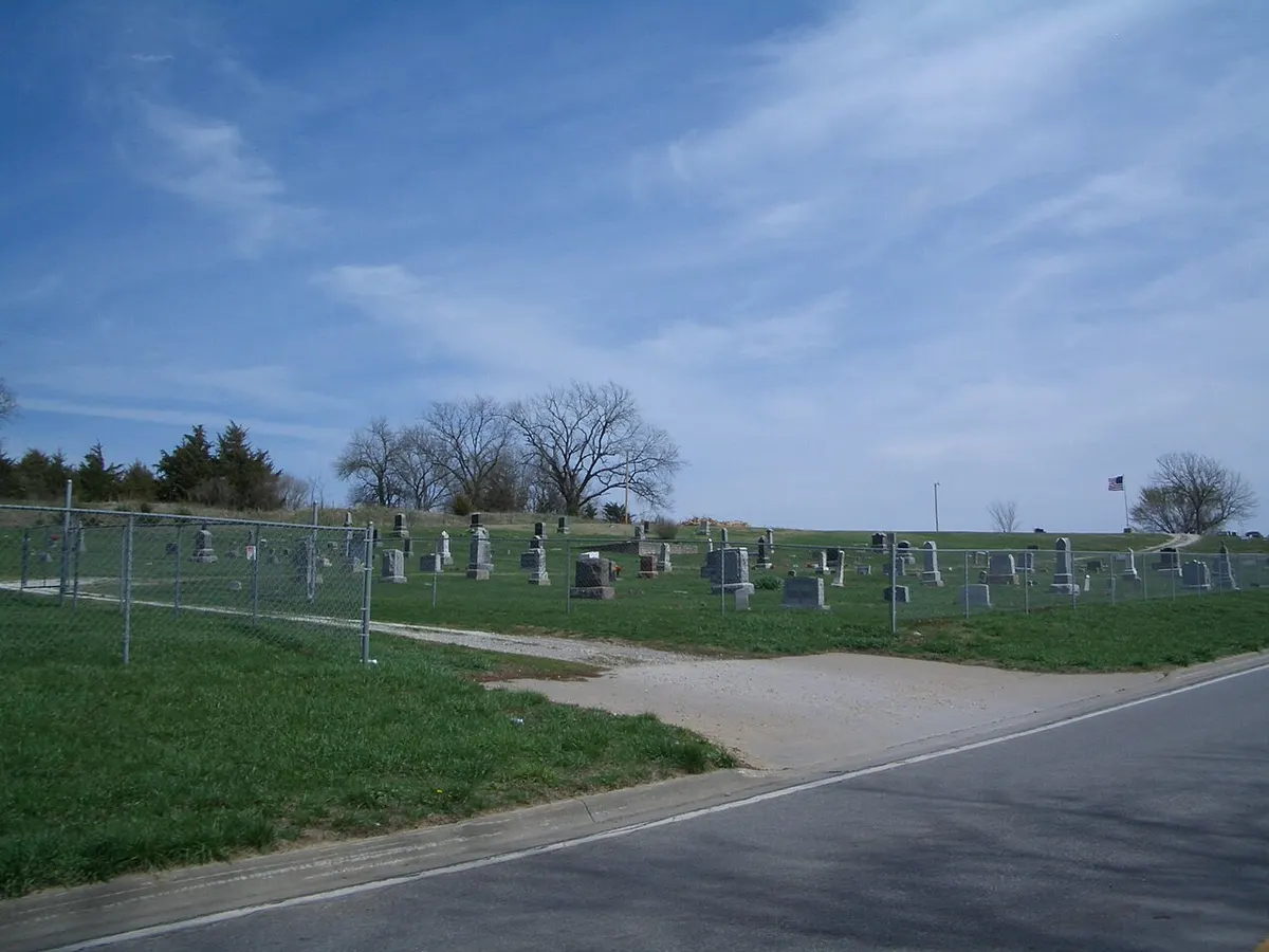 Gravestones in Stull Cemetery, Kansas, with the ruins of the old stone church in the background