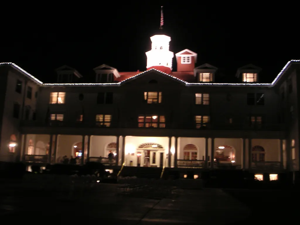 The white Stanley Hotel lit up at night in Estes Park, Colorado